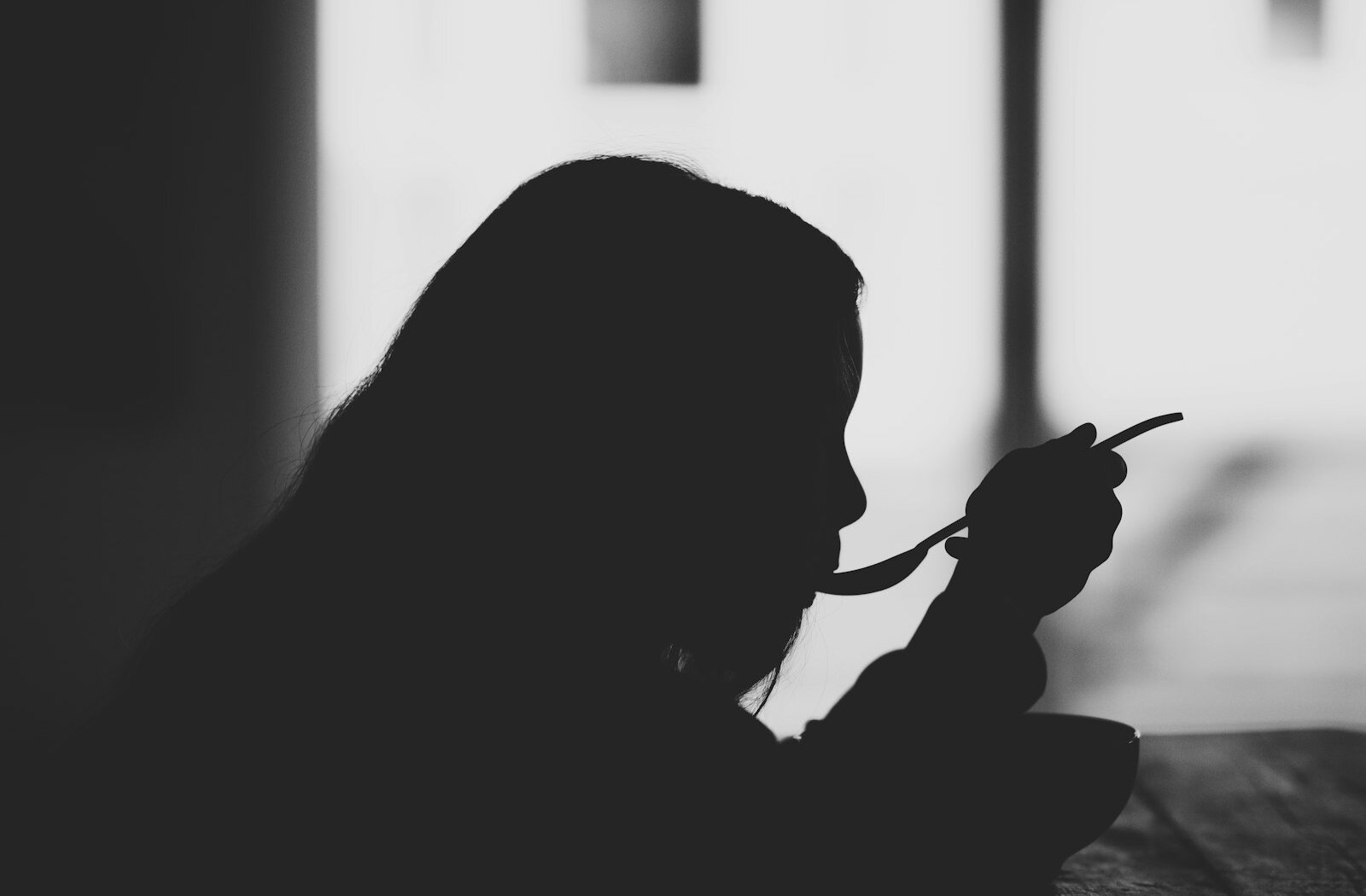 숟가락으로 식사하는 사람의 옆모습 실루엣