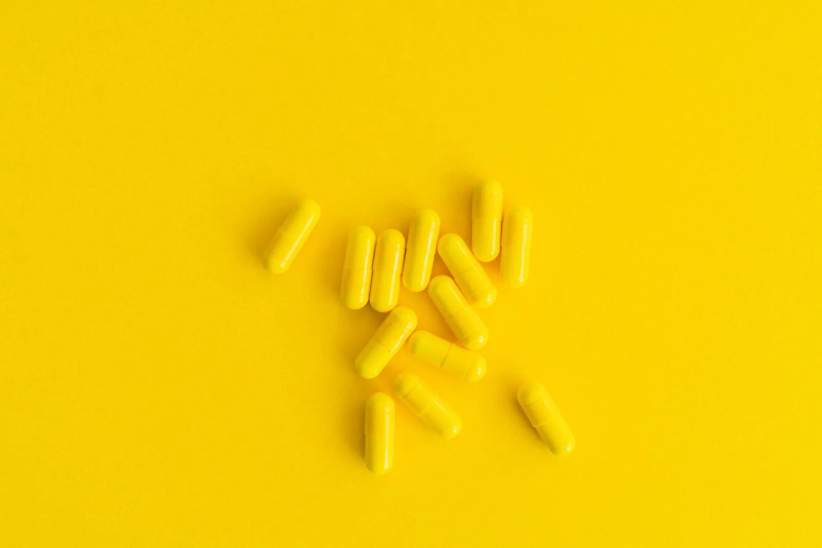 Stock photo of yellow capsules on a yellow background, not the actual rexaceract product