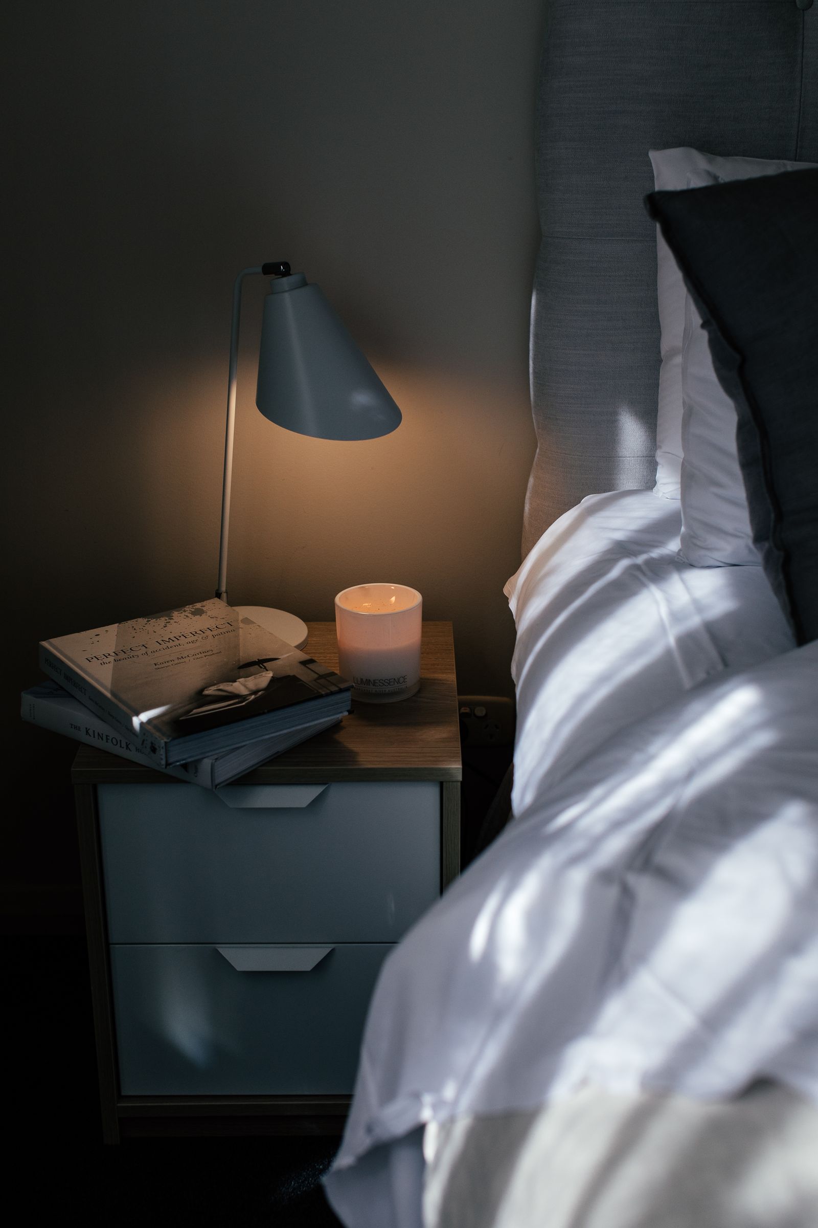 Stock photograph of a bed and bedside lighting in an empty bedroom