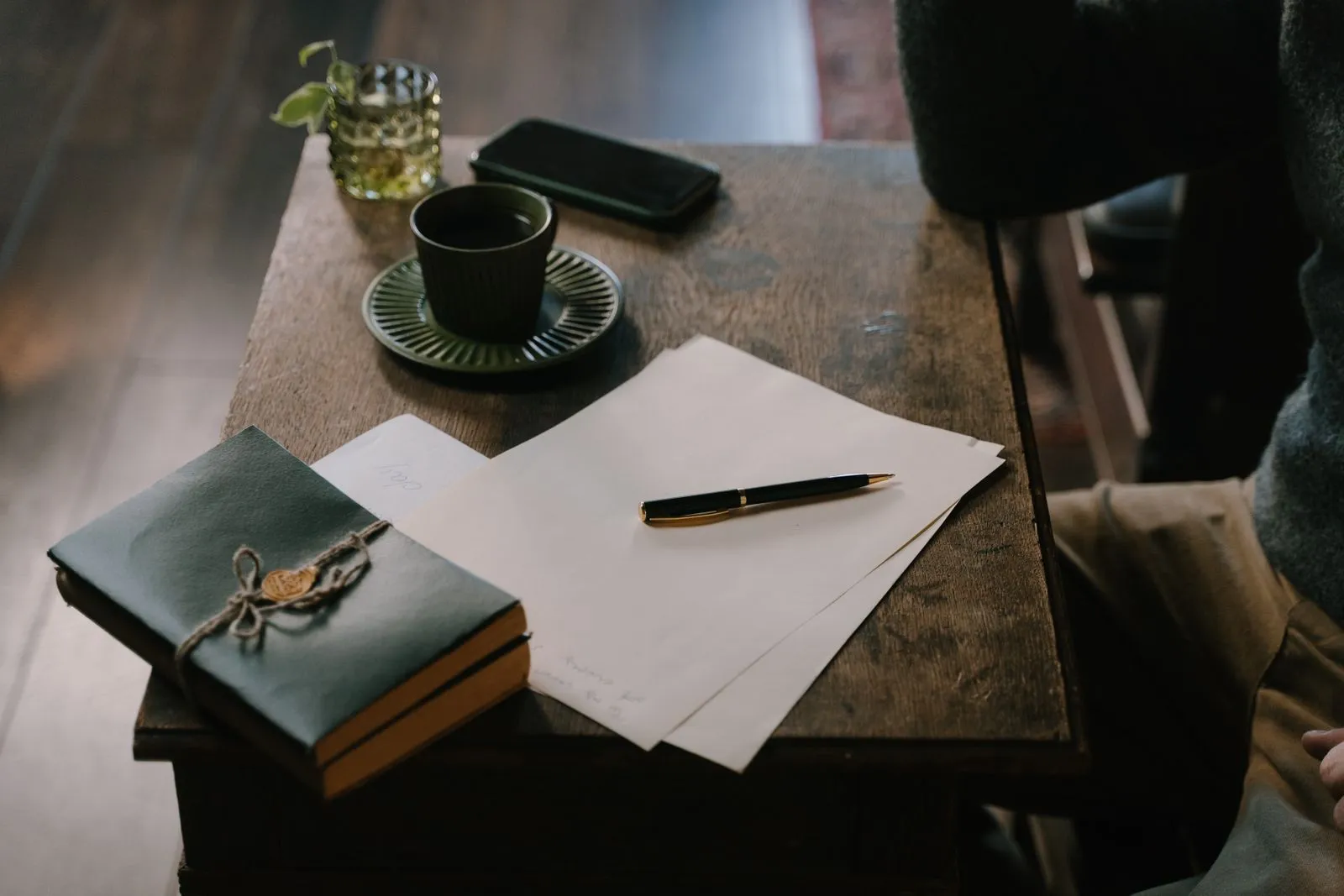 A cup, paper and pen on a table