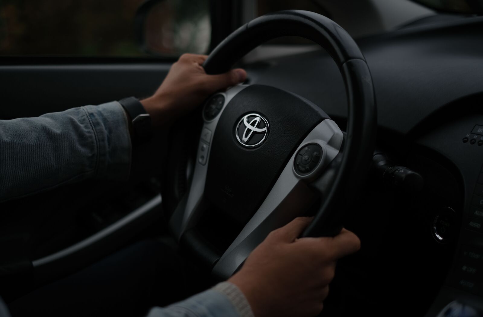 運転席でハンドルを両手で握る様子