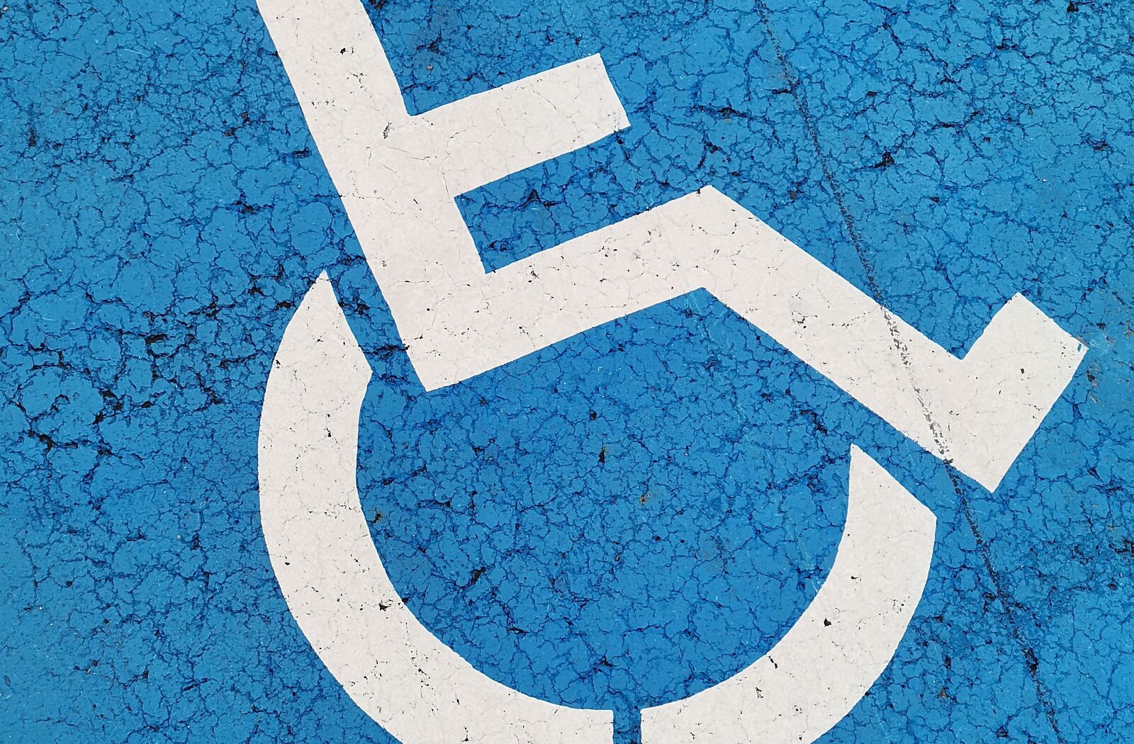 Símbolo de estacionamiento para personas con discapacidad pintado en el pavimento